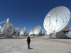 Recent image of Paola Caselli at the site of the ALMA Observatory. The "Atacama Large Millimeter/sub-millimeter Array" is an interferometer of 66 high-precision radio telescopes in the Atacama desert in Northern Chile. The telescope array will observe at millimetre and sub-millimetre wavelengths to probe the very first stars and galaxies, and directly image exo-planets, possibly discovering the first traces of life.