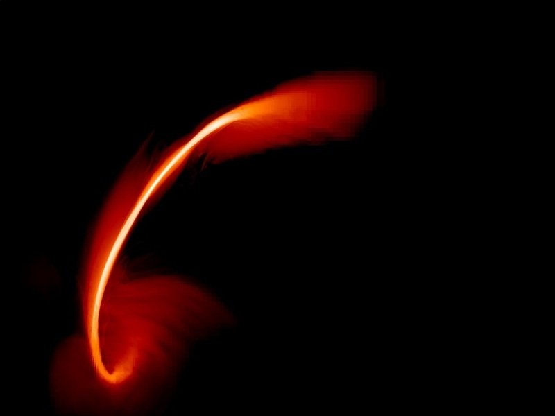 A snapshot image from a computer simulation of a star disrupted by a supermassive black hole. The red-orange plumes show the debris of the star after its passage near the black hole (located close to the bottom left corner of the image). About half of the disrupted star moves in elliptical orbits around the black hole and forms an accretion disc which eventually shines brightly in optical and X-rays.