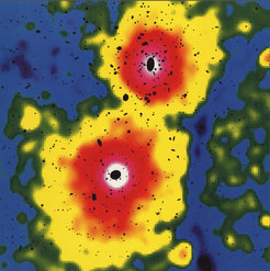 Galaxienhaufen sind die größten physikalischen Objekte im Universum. Das System A3528 zeigt zwei Haufen, die gerade miteinander verschmelzen. Die Röntgenemission ist durch Farben dargestellt, die optische Strahlung der einzelnen Galaxien ist durch die schwarzen Ellipsen angedeutet. In wenigen hundert Millionen Jahren wird die Verschmelzung abgeschlossen sein und zu einem größeren Galaxienhaufen geführt haben.