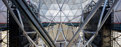 Die zwei scharzen Blöcke rechts und links des Hauptspiegels des Hobby-Eberly Telescope haben den Spitznamen "die Satteltaschen" bekommen. Es handelt sich hierbei um das VIRUS-Instrument, das mit Dutzenden Spektrographen das HETDEX-Experiment durchführt.