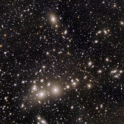 Quadratisches Bild mit schwarzem Hintergrund und Ansammlung verteilter punktförmiger weißer Lichtquellen neben vielen kleinen und größeren verschwommenen Flecken