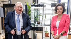 Direktor Reinhard Genzel und Forschungsministerin Dorothee Bär stehen von der Vitrine mit der Nobelpreismedaille, die Genzel 2020 erhielt.